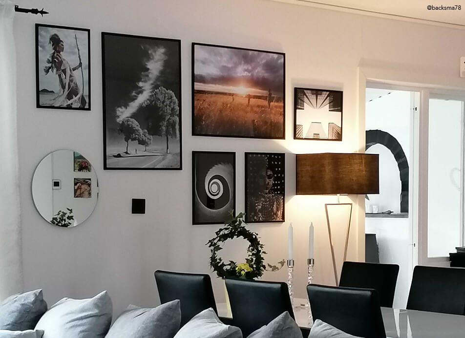 Bilderwand mit Spiegel und schwarzen Bilderrahmen